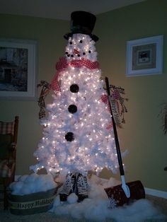 a white christmas tree decorated with lights and a snowman