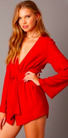 Red Romper. The What If Red Long Sleeve Wrap Romper will make everyone wish they were you! Lightweight fabric in a paprika red hue shapes a plunging neckline wrap bodice that secures around a front tie waist. Attached asymmetric skort and long bell sleeves finish the chic elegant took. Party Top With Tie Waist And V-neck, Party V-neck Top With Tie Waist, V-neck Top With Tie Waist For Party, Chic V-neck Wrap Top With Tie Waist, Fitted V-neck Wrap Top In Solid Color, Fall V-neck Wrap Top With Tie Waist, V-neck Wrap Top For Party, V-neck Wrap Top For Night Out In Spring, Spring V-neck Wrap Top For Night Out