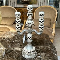 a table topped with lots of skulls on top of a marble counter next to chairs