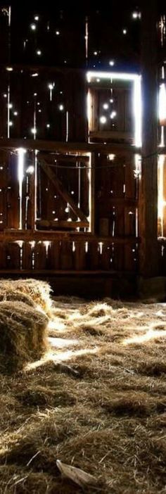 hay bales in front of a barn at night