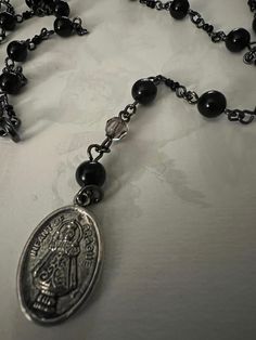 Handmade black beaded rosary.  20 in long with religious charm. Bead and chain work.  In good condition. Vintage Black Rosary As A Gift, Vintage Black Rosary As Gift, Black Spiritual Rosary Bracelet With Cross, Vintage Black Rosary Gift, Black Beaded Cross-shaped Rosary, Black Beaded Cross Rosary, Black Rosary Bracelet With 8mm Beads For Jewelry Making, Black Crucifix Rosary Bracelet As Gift, Black Crucifix Rosary As Gift