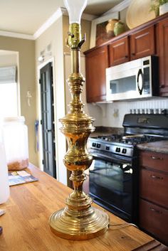 a golden candle holder sitting on top of a wooden counter in a kitchen next to an oven