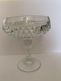 an empty glass bowl sitting on top of a table