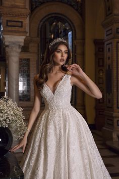 a woman in a wedding dress posing for the camera with her hand on her hip