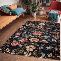 a black rug with flowers on it in front of a couch and bookshelf