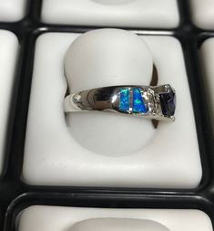 Fabulous brand new high quality silver ring with lab created blue inlay Fire Opals and 7mm Trillion cut Tanzanite, and White Topaz stones set on solid 925 sterling silver and stamped with 925. Our silver is genuine 925 sterling silver and Rhodium plated for better quality and prolonged shine. You will receive the item in a gift box Thanks for looking and check out more items in my Etsy shop for more great items and deals! https://www.etsy.com/shop/925usa Payment: We accept all major credit cards Silver Opal Ring With Multi-stone Round Cut, Silver Multi-stone Round Cut Opal Ring, Silver Trillion Cut Sapphire Ring With Accent Stones, Sterling Silver Opal Ring With Accent Stones, Silver Opal Ring With Accent Stones, Round Cut, Blue Trillion Cut Sterling Silver Ring, Blue Sterling Silver Rings With Channel Set, Sterling Silver Channel Set Sapphire Promise Ring, Gift Sapphire Ring Channel Set In Sterling Silver