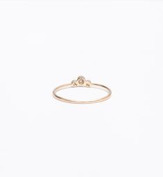 A slightly larger center and offset, delicate sides impart this delicate stacking ring with just the right amount of size and an unexpected silhouette. Though you can easily wear it on its own, you'll find a million ways to stack it thanks to the tiny space its curved design makes. Nestle it alongside other delicate rings for a multitude of sparkle or let it snuggle alongside a chunkier signet ring for maximum impact. Made in the U.S.A. Center setting measures 0.25" wide. 14 karat gold with thre Minimalist Round Diamond Ring With Smooth Bezel, Minimalist Stackable Rings With Round Diamond Band, Minimalist Stackable Diamond Ring With Round Band, Minimalist Diamond Stackable Rings With Round Band, Minimalist Stackable Round Cut Diamond Ring, Minimalist Oval Diamond Stackable Rings, Minimalist Diamond Ring With Smooth Bezel, Minimalist Stackable Round Band Diamond Ring, Minimalist Round Diamond Ring With Bezel Setting