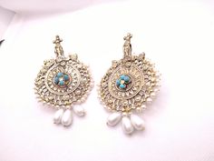 * This astonishing pair earing is a classical ornament, embellished with various elements and fine work. * The Bohemian inspired earrings feature craved motifs, Feruza stones and tinny dangling white beads. * The huge sized earrings would complete your stylish look and would add a pinch of ethnic touch to your modish look. * We assure you the High-Quality Product with On Time Delivery * Traditional Chandbali Clip-on Earrings, Unique Pearl Drop Earrings For Wedding, Unique Wedding Pearl Drop Earrings, Traditional Round Clip-on Earrings For Festive Occasion, Silver Pierced Pearl Earrings For Festive Occasions, Bohemian Pearl Drop Earrings, Festive Silver Pearl Pierced Earrings, Bohemian Bridal Earrings With Intricate Design, Chandbali Earrings For Festival