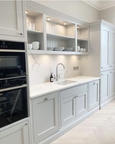 a kitchen with an oven, sink and cabinets in the middle of the floored room