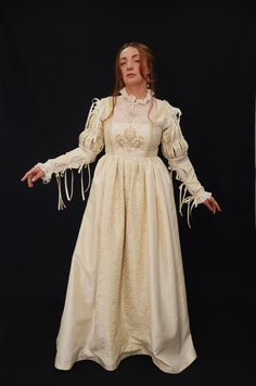 This beautiful Renaissance-style dress is made with taffeta creme ivory fabric and ivory and gold brocade fabric. The chamise dress is made from transparent opaque organza fabric with handmade beads and pearl embroidery. This price includes the dress, the detachable sleeves, and the CHEMISE dress. available in size 10 UK, 8 USA, M  Suitable for the following measurements : High 168 cm Bust 92-98 cm          36.2- 38.5in Waist 74-80 cm            29.1- 31.4 in Arm perimeter 28-32 cm Taffeta Dress With Lined And Fitted Bodice, Fitted Taffeta Dress With Lined Bodice, Taffeta Ball Gown Wedding Dress, Satin Victorian Ball Gown For Costume Party, Fitted Taffeta Dress For Wedding, Formal Long Sleeve Taffeta Dress, Fitted Taffeta Wedding Dress, Elegant Long Sleeve Victorian Dress For Fancy Dress, Elegant Fitted Vintage Dress For Fancy Dress