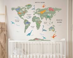 a baby's room with a map of the world on the wall and dinosaur decals