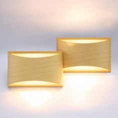 two wooden lights that are next to each other on a wall or floor in front of a white background