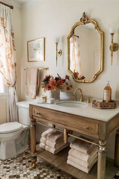 a bathroom with a sink, mirror and toilet in it's centerpieces