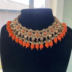 This gorgeous Orange Necklace set is made from fine polki stones. Comes as a set with earrings and a head piece. ALL SALES ARE FINAL ON JEWELRY. KINDLY MESSAGE ME FOR ANY INQUIRIES. Festive Bollywood Kundan Jeweled Necklace, Festive Bollywood Jeweled Kundan Necklace, Bollywood Style Jeweled Kundan Necklace For Festivals, Bollywood Style Jeweled Kundan Necklace For Festive Season, Festive Gold Jeweled Beaded Necklaces, Festive Costume Jewelry Sets With Jewels, Jeweled Kundan Necklace For Diwali Party, Bollywood Style Jeweled Chandbali Necklaces, Bollywood Chandbali Jeweled Necklaces