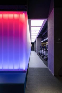 an empty hallway with blue and pink lighting