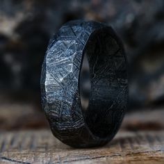 It's time that one of our favorite finishes came to one of our favorite rings. The obsidian meteorite ring shows our classic meteorite ring in a new light. Handcrafted from a solid piece of meteorite, a unique pattern is applied by adding a random assortment of facets, by hand, to create a truly one of a kind ring.  Ho Unique Wedding Rings For Him, Cool Wedding Rings Unique, Unique Men’s Wedding Rings, Men’s Rings, Meteorite Ring Men, Meteorite Wedding Ring, Unique Mens Wedding Bands, Faceted Wedding Bands, Meteorite Engagement Ring