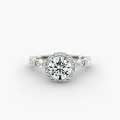 a white gold engagement ring with diamonds on the band and an oval center stone in the middle