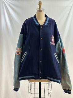 This vintage 90s American Eagle Outfitters jacket is so cool. Varsity style, it as wool body with denim sleeves and colorful embroidered patchwork on arms as well as the back.   -Vintage 90s -Wool and denim, colorful embroidered patchwork -Dry clean only Measurements:  marked a men's extra large *Sleeve 25 inches *Bust 29 inches *Length 26 1/2 inches *Bottom opening 25 1/2 inches *This item is pre-loved and there may be minor flaws to the garment. Not to worry if there is anything major we will Winter Cotton Varsity Jacket With Patchwork, Retro Cotton Varsity Jacket With Patchwork, Cotton Varsity Outerwear With Patchwork, Cotton Patchwork Varsity Jacket For College, Retro Cotton Outerwear With Patches, Retro Outerwear With Embroidered Patch And Long Sleeves, Blue Varsity Jacket With Patchwork, Blue Patchwork Varsity Jacket, Retro Long Sleeve Outerwear With Embroidered Patch