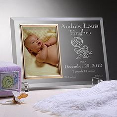 a baby's birth announcement is displayed in front of a photo frame and stuffed animal