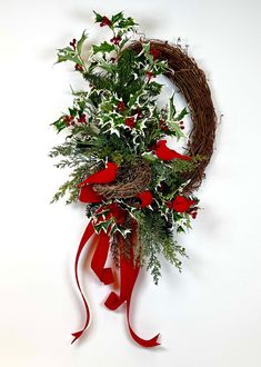 a christmas wreath with red bows and greenery