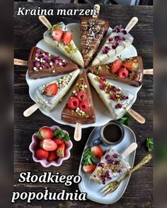 desserts are arranged on plates with strawberries and other foods in the middle, along with utensils