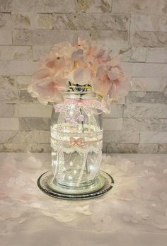 a glass jar filled with flowers on top of a table