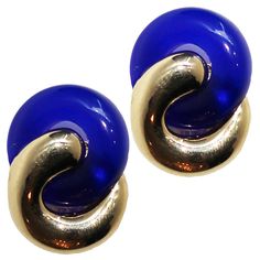 These clip on earrings feature a figure eight pattern created with metallic gold and translucent blue resin.    1.5" Length  Resin, 24 karat clad base metal  Nickel and Lead Free  This item may also be special ordered using our custom color chart.  Made in Italy Blue Round Clip-on Jewelry, Gold Lucite Earrings For Gifts, Gold Lucite Earrings As A Gift, Blue Clip-on Earrings As Gift, Mid Century Earrings, 22k Gold, Base Metal, Color Chart, Metallic Gold