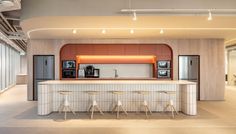 an open kitchen with bar stools next to it