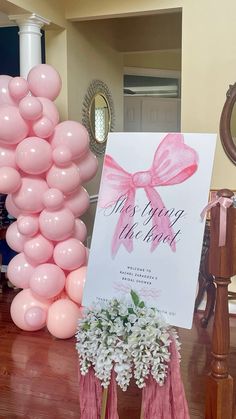 a pink balloon arch with a sign that says, it's your birthday