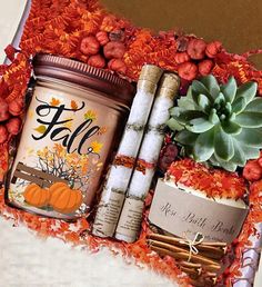 an autumn gift basket with candles, pumpkins and other items