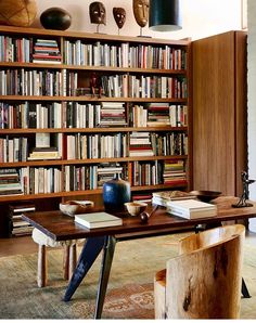 a wooden table sitting in front of a bookshelf filled with lots of books