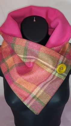 a pink and yellow plaid scarf on a mannequin's head with a button