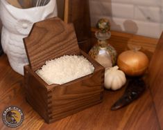 a wooden box filled with rice sitting on top of a table next to other kitchen utensils