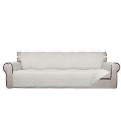 a white couch with a quilted cover on the back and armrests, in front of a white background