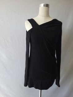 You will be " So Chic" and sexy in our shirring detail asymmetric long sleeve top. This top with hug you un all the right places and also feel comfortable with the soft,lightweight ,stretchy material. Featuring cut out right shoulder, asymmetric neckline, solid black color, long sleeves and hits you below the waist. Paired with our ''Roize'' jeans but can pair also with some distressed jeans. Rayon/Spandex Fit: True to size Made in U.S.A Machine wash cold Hang dry Stretch Top With Ruched Asymmetrical Neckline, Ruched Top With Stretch And Asymmetrical Neckline, Asymmetrical Neckline Top With Ruched Stretch, Asymmetrical Neckline Top With Ruched Detail, Fall Ruched Asymmetrical Top, Black Stretch Draped Top, Black Draped Stretch Top, Stretch Ruched Long Sleeve Blouse, Stretch Long Sleeve Blouse For Night Out