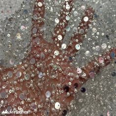 a person's hand is covered with water droplets