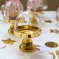 a table topped with lots of glass vases filled with water and gold flakes