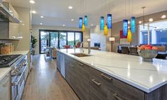 a kitchen with an island, stove and dining room in the backgrounge