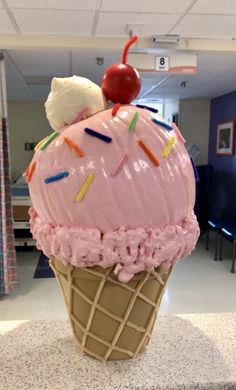 an ice cream sundae with sprinkles and a cherry on top in a classroom