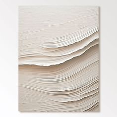 an abstract painting with wavy lines in white and neutral colors on the wall above it