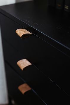 a black dresser with wooden handles and drawers