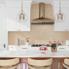 a kitchen with marble counter tops and stools in front of the stove top oven