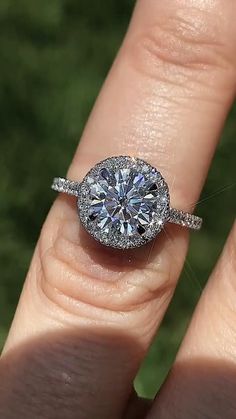 a woman's hand with a diamond ring on top of her finger and an engagement band