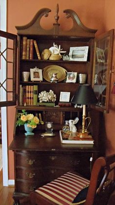 an antique desk and chair in the corner of a room