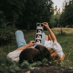 two people laying in the grass with their feet up and one person holding an open book