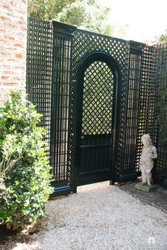 an iron gate in the middle of a garden