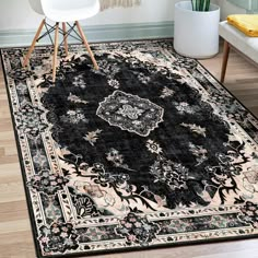 a black rug with an ornate design on the floor in front of a white chair