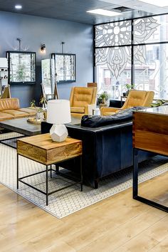 a living room filled with lots of furniture next to large windows and wooden flooring