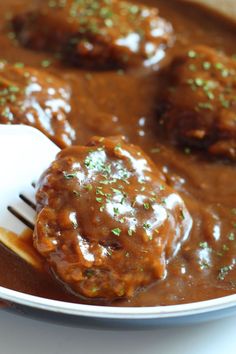 meatballs covered in gravy on a spoon