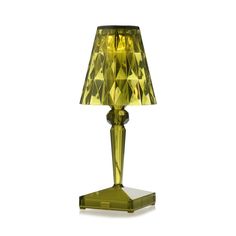 a green glass table lamp with a yellow shade on it's base and a white background